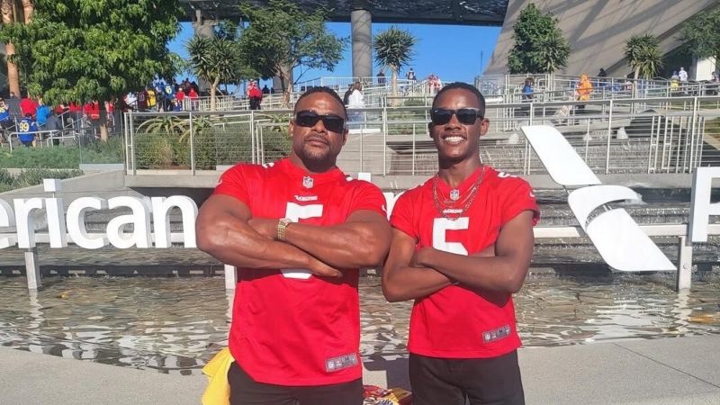 Lamar and Josiah Willis are wearing their jerseys and posing for a photo with their arms crossed