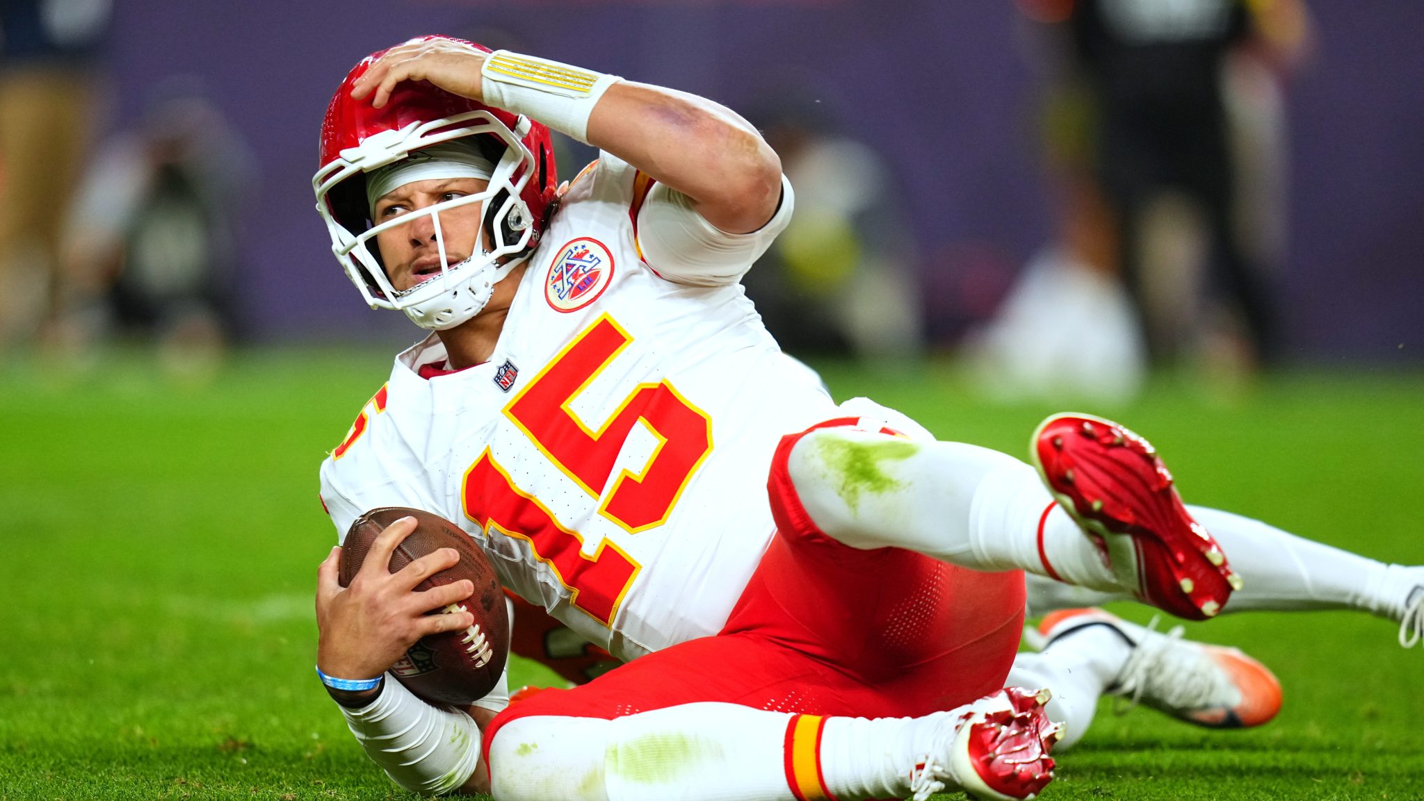 Patrick Mahomes is on the ground holding his head after getting sacked.