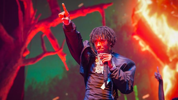 NBA Youngboy stands on the stage with his hand up, during a performance in Atlanta, GA.