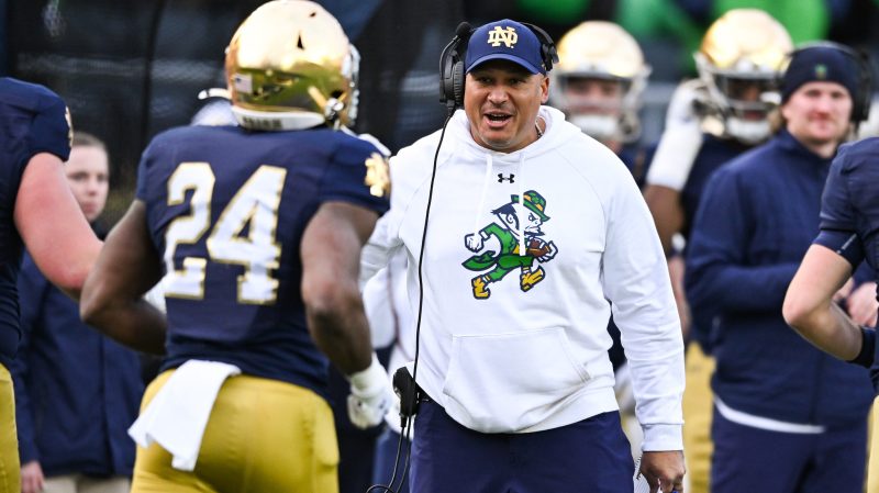 Ja'Juan Seider (center), Notre Dame's associate head coach and running backs coach, talks with players during a game against Syracuse on Nov. 22, 2025, at Notre Dame Stadium in South Bend, Indiana.