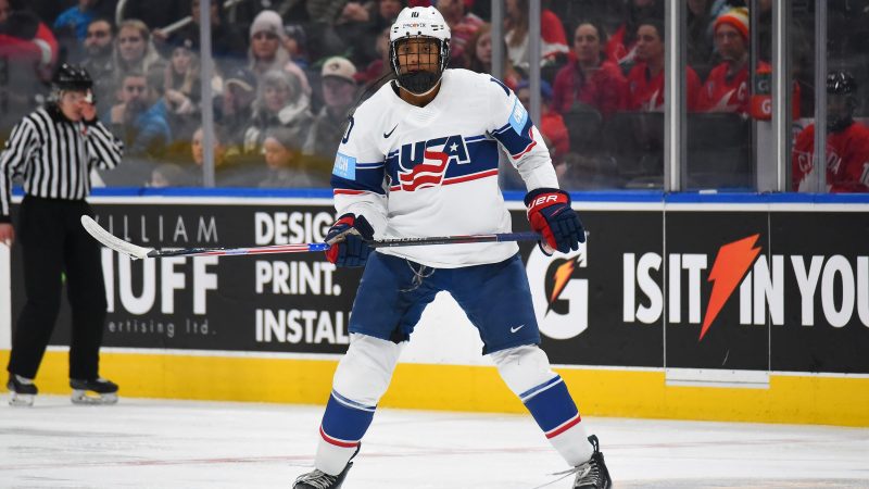 Laila Edwards holds a hockey stick on the ice.