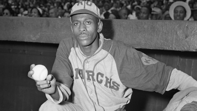 Satchel Paige stands at the top of the dugout with baseball in hand in 1942.