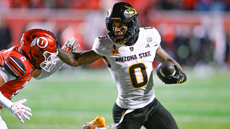 Jordyn Tyson stiff-arms a defender and runs with the ball.