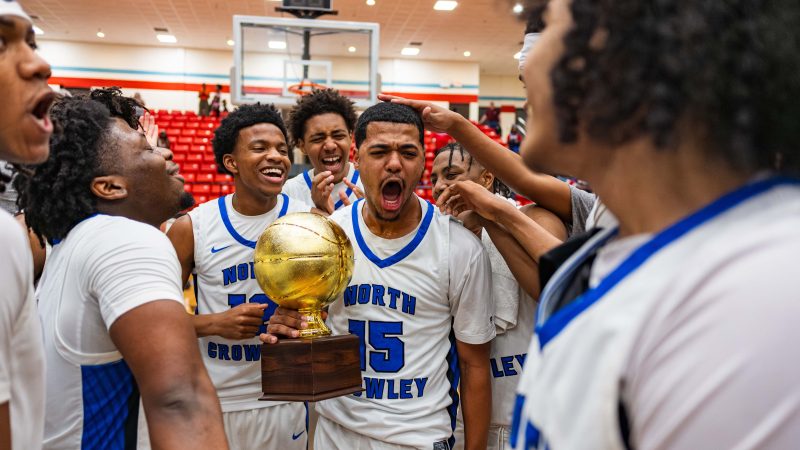 Tyler Hastings holds a trophy and celebrates with teammates