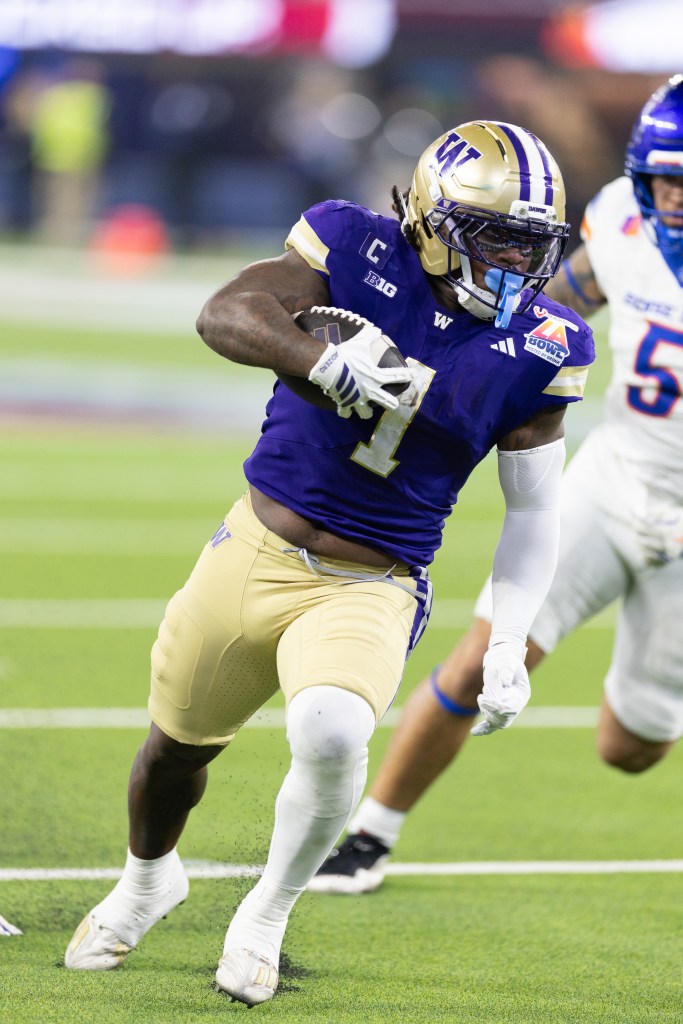 Jonah Coleman carries the ball as a defender chases him.