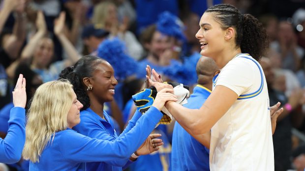 UCLA center Lauren Betts (right) high-fives assistant coach Michaela Onyenwere (center) and other staff members during the fourth quarter of the women's NCAA tournament championship game on April 5, 2026, at Mortgage Matchup Center in Phoenix.