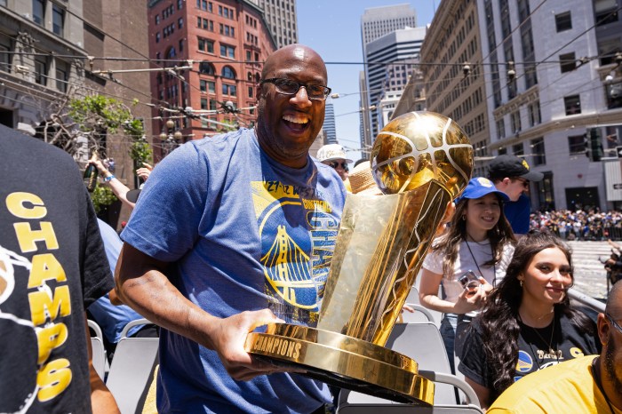 Mike Brown holds the NBA trophy during the Golden State Warriors championship parade.