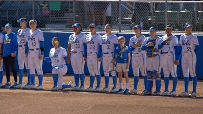 UCLA's Jordan Woolery (fourth from left) kneels during the national anthem before a game against Wisconsin on March 8, 2026, at Easton Stadium in Los Angeles.