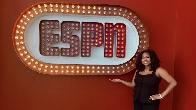 Rhoden Fellow Raigan Lydon of Morgan State stands in front of the original ESPN logo, at ESPN headquarters in Bristol, Conn., on the second day of her fellowship.