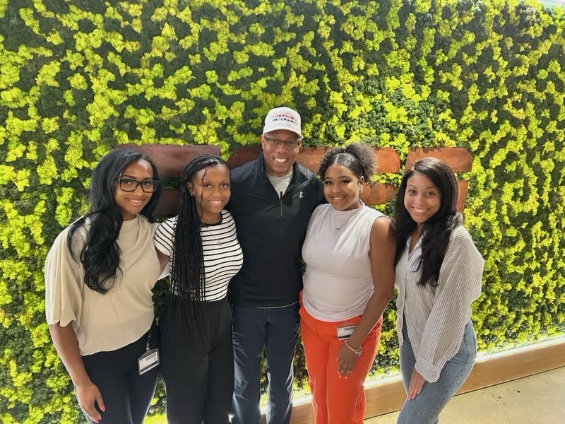 The Class of 2026 Rhoden Fellows -- Ciara Latham (from left), Alauna Marable, Raigan Lydon and Calandrea Carter -- surround SportsCenter anchor Jay Harris at ESPN headquarters in Bristol, Conn. Kimberly Jarvis / Andscape