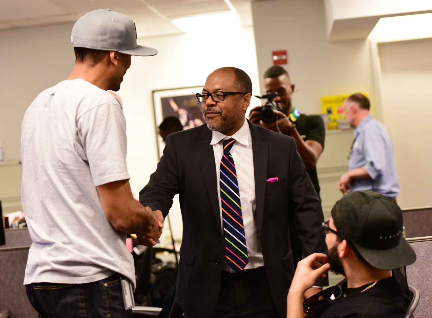 Kevin Merida shakes Jesse Washington's hand.