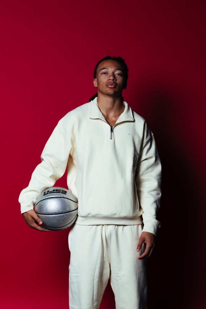 Kingston Flemings poses for a photo with a silver basketball in his right arm.