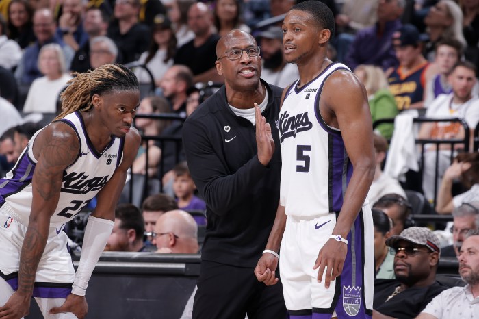 Mike Brown talks to his Sacramento Kings players on the sidelines.