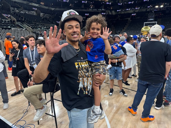 Elijah Brown and Elijah's son, Iverson wave to the camera after the New York Knicks won the NBA title.