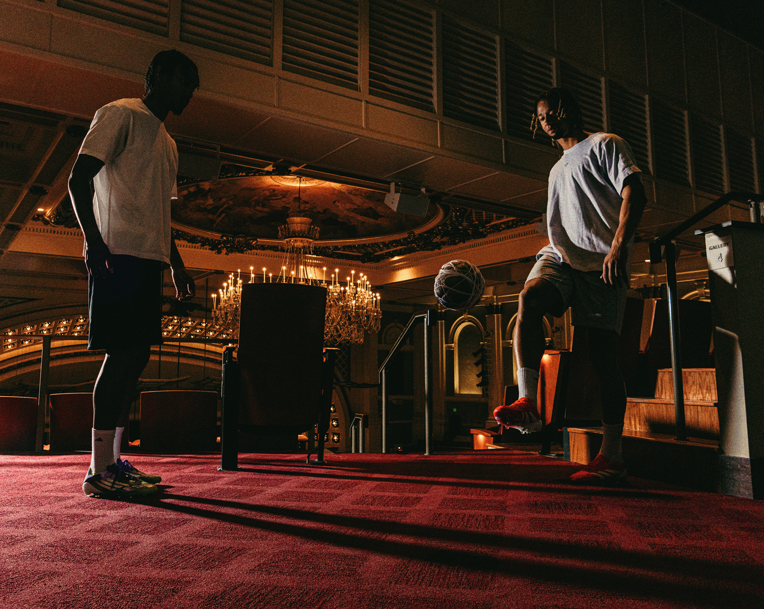 Kenji Mboma Dem (from left) and Ayoub Jabbari pass a ball made of plastic bags and string back and forth in Music Hall in Cincinnati.