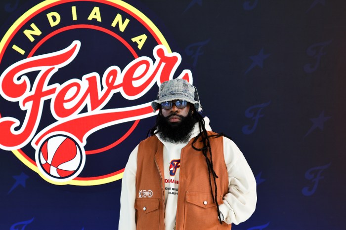 Jas Bell poses in front of the Indiana Fever logo.