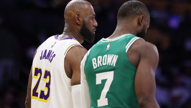 LeBron James talks to Jaylen Brown on the court.