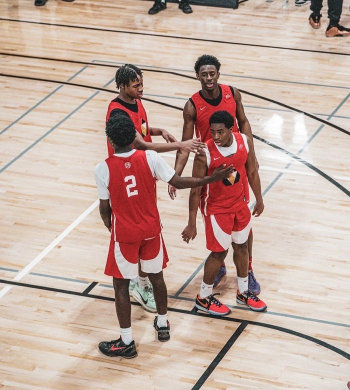 A group of PSA basketball players huddle on the court.