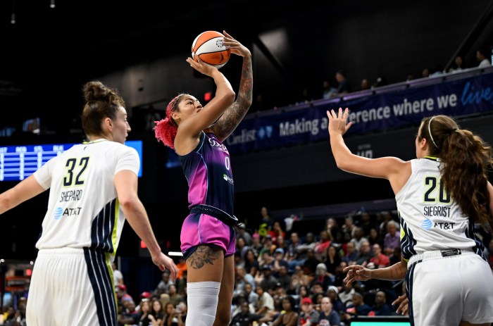 Shakira Austin (center) of the Washington Mystics shoots the ball over the Dallas Wings' Jessica Shepard (left) and Maddy Siegrist (right) on July 31, 2026, at CareFirst Arena in Washington, D.C.