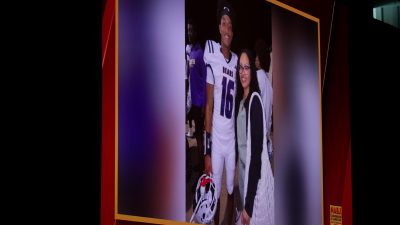 A still image of Nolan Wells wearing his football uniform with his mom Christine Wonsley is shown on a screen.
