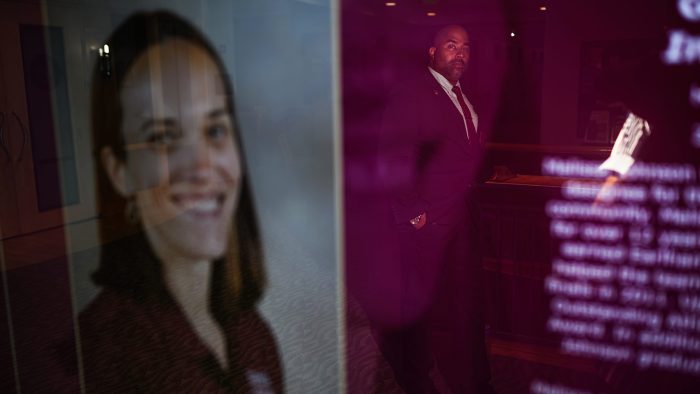 Nick Johnson stands for a portrait in the reflection of Melissa Johnson’s Athletics Hall of Fame display