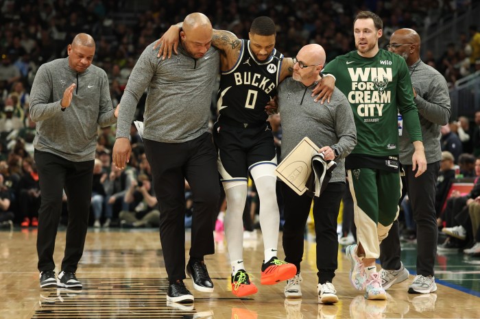 Damian Lillard is helped off the court after an injury.