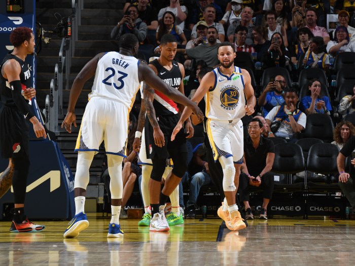 Draymond Green and Stephen Curry high five during the game