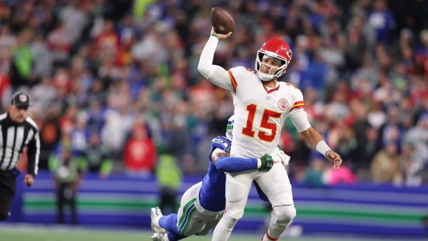 Patrick Mahomes is hit by safety Nick Emmanwori as he throws.