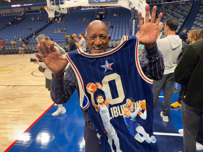John Haliburton smiles as he holds up a jersey of his son Tyrese Haliburton.