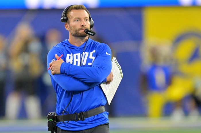 Sean McVay has his arms folded as he watches from the sidelines.